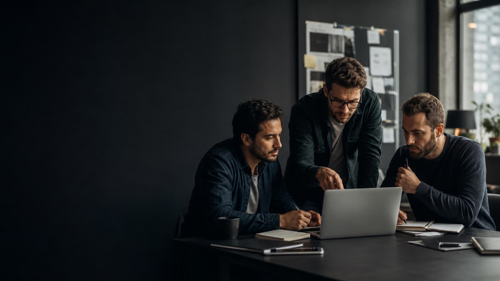Three male AI builders collaborating around a laptop
